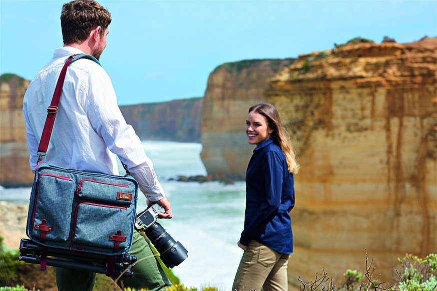 Fotograf fotí slečnu u útesu a má přes rameno batoh National Geographic Australia 3-Way Backpack.