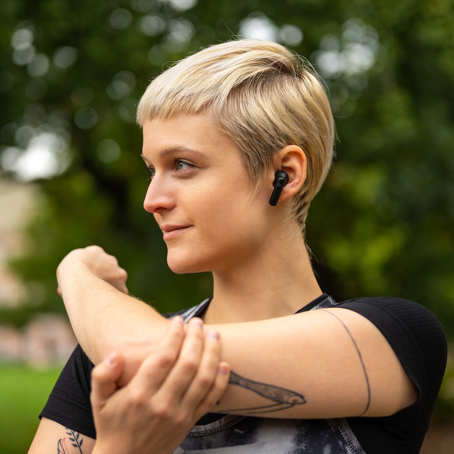 Žena cvičiaca so slúchadlami Niceboy HIVE Pins v ušiach