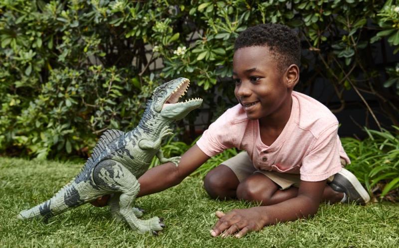 Chlapec si hraje s hračkou dinosaura z Jurského světa od značky Mattel
