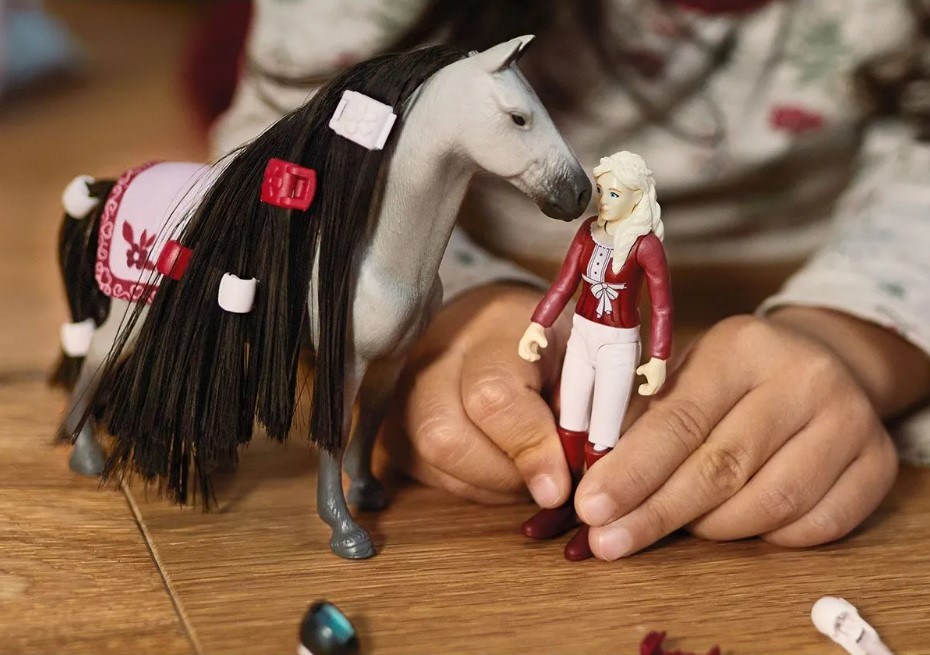 Dievčatko sa hrá s bábikou Sofiou a jej koňom Dustym