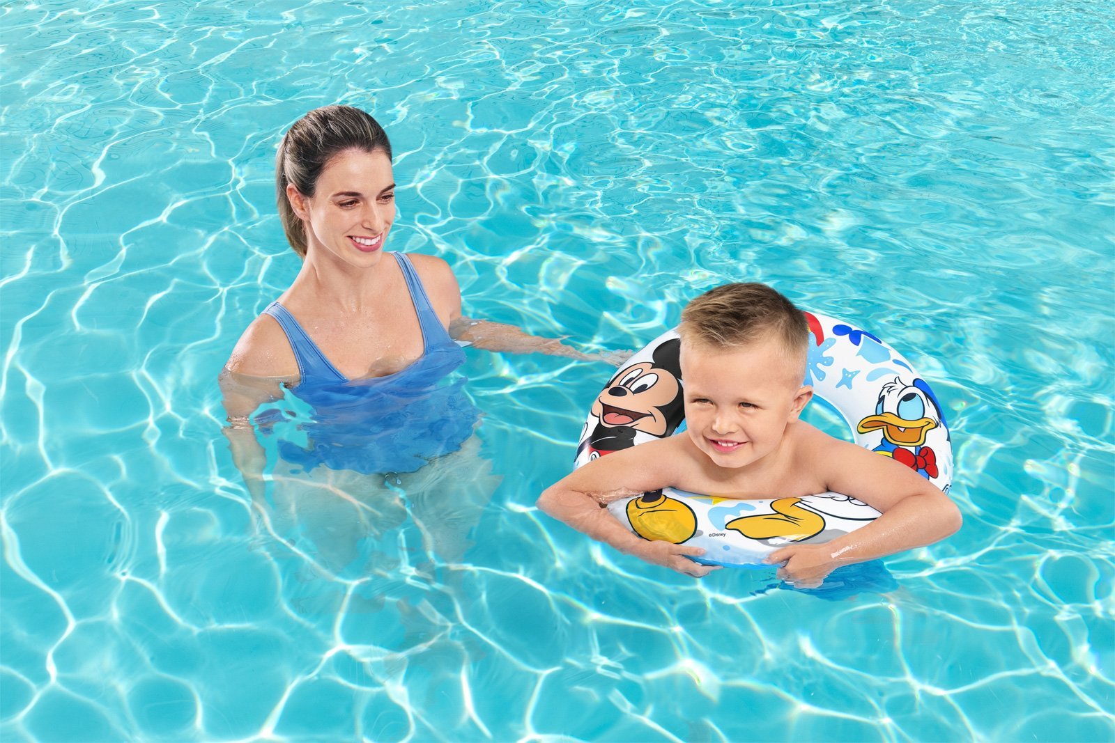 Maminka učí syna plavat v bazénu pomocí nafukovacího kruhu Bestway Mickey