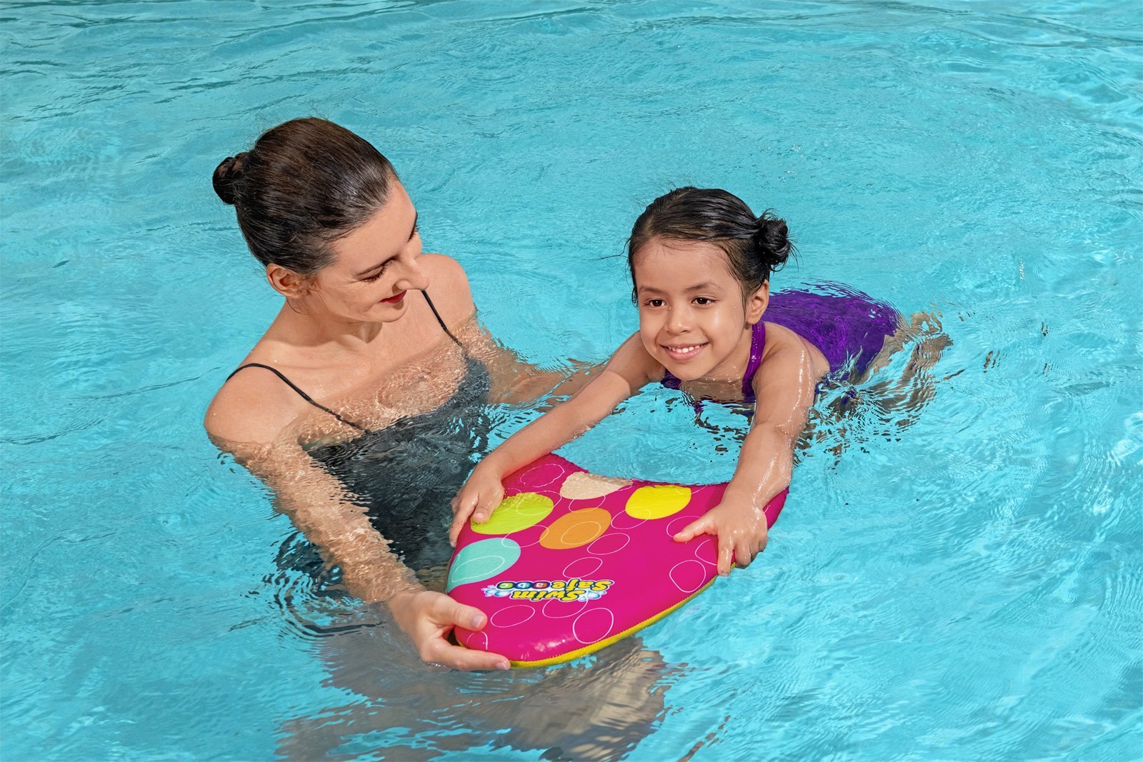 Maminka učí dceru plavat v bazénu pomocí plovací desky Bestway