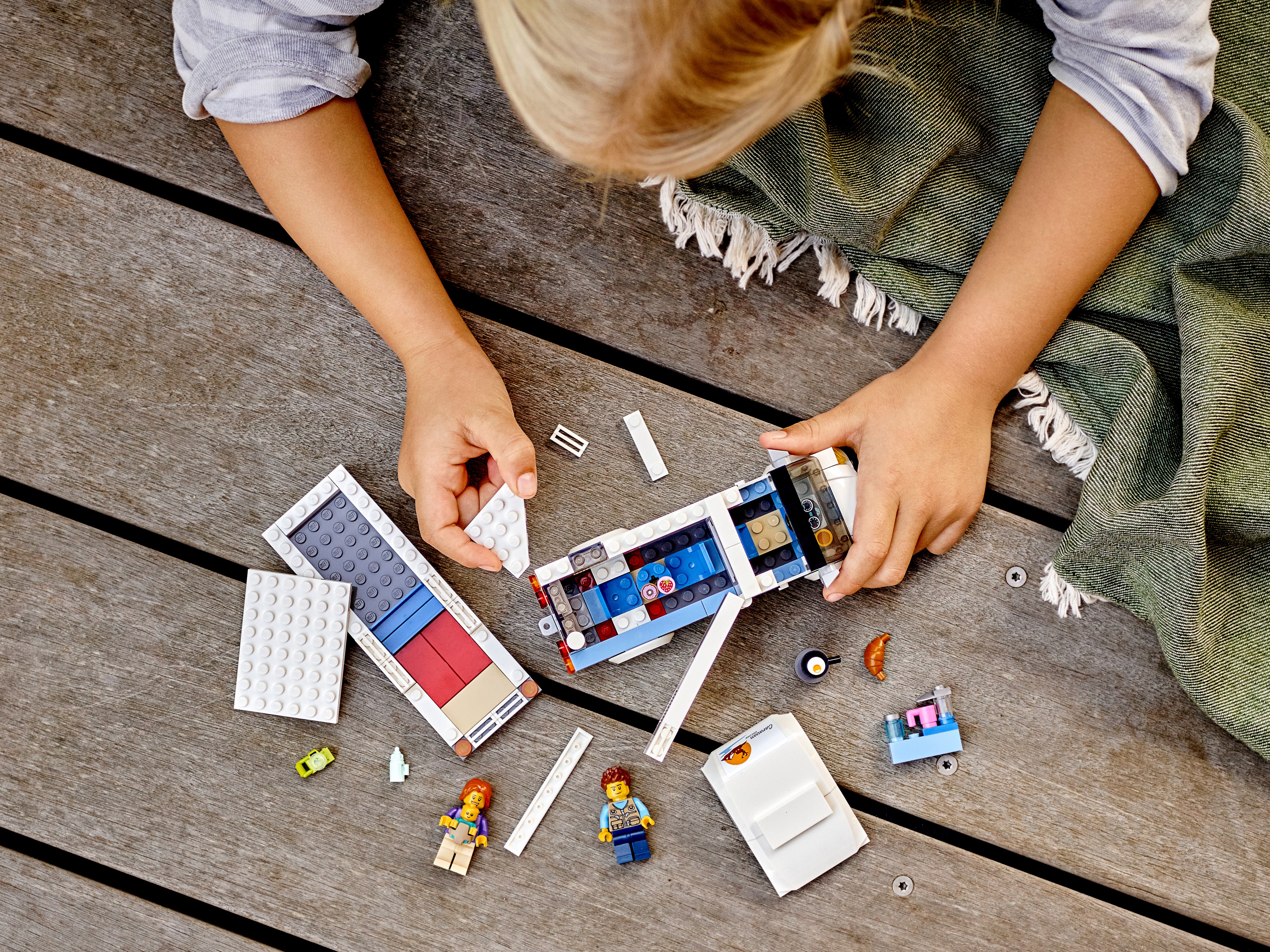 Holčička staví prázdninový karavan ze stavebnice LEGO
