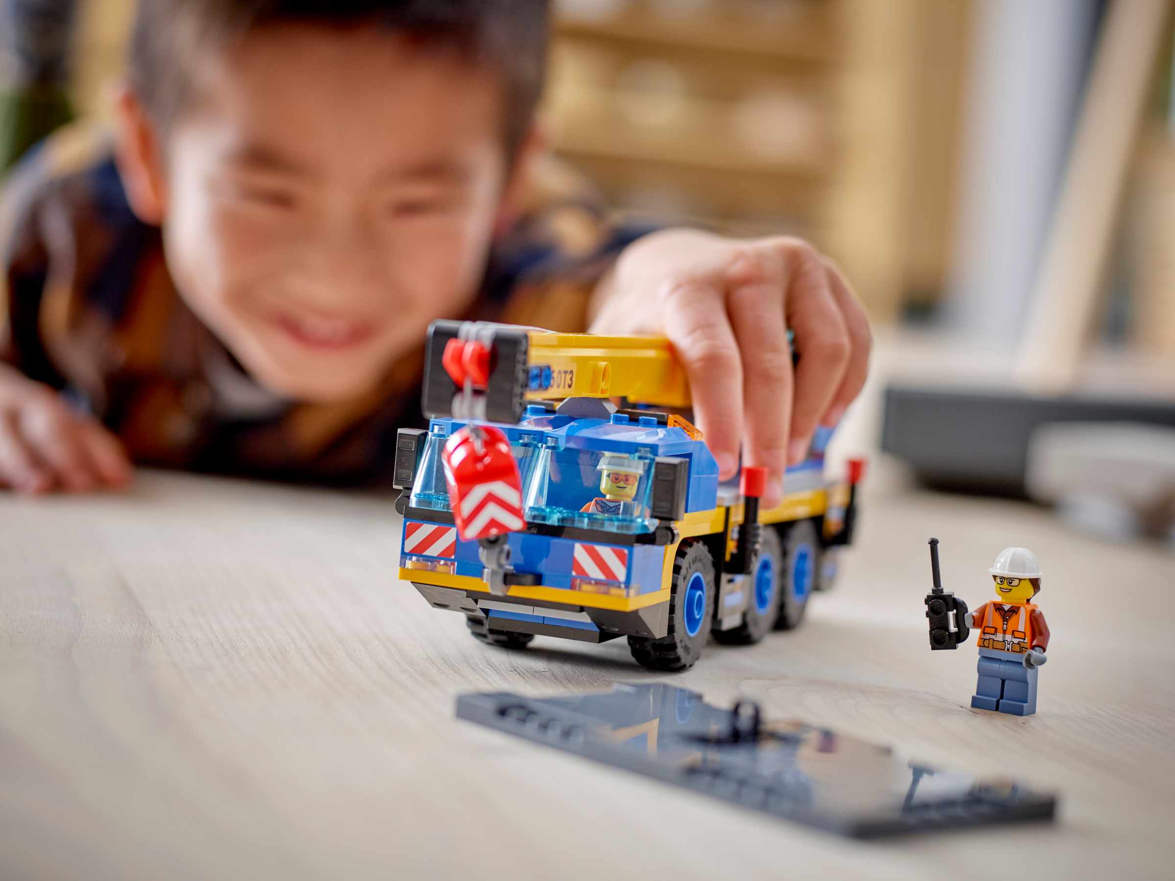 Chlapec si hraje s jeřábem ze stavebnice LEGO